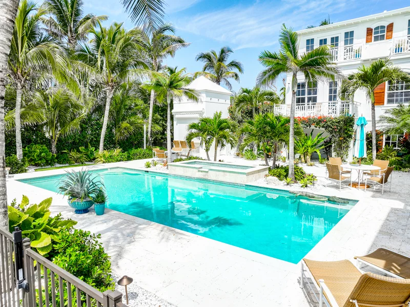 Swimming pool surrounded by palms and tropical landscaping