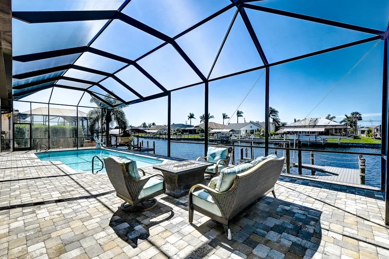 Screened pool and seating overlooking a waterfront canal